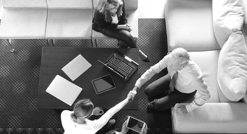 Overhead business handshake at meeting table