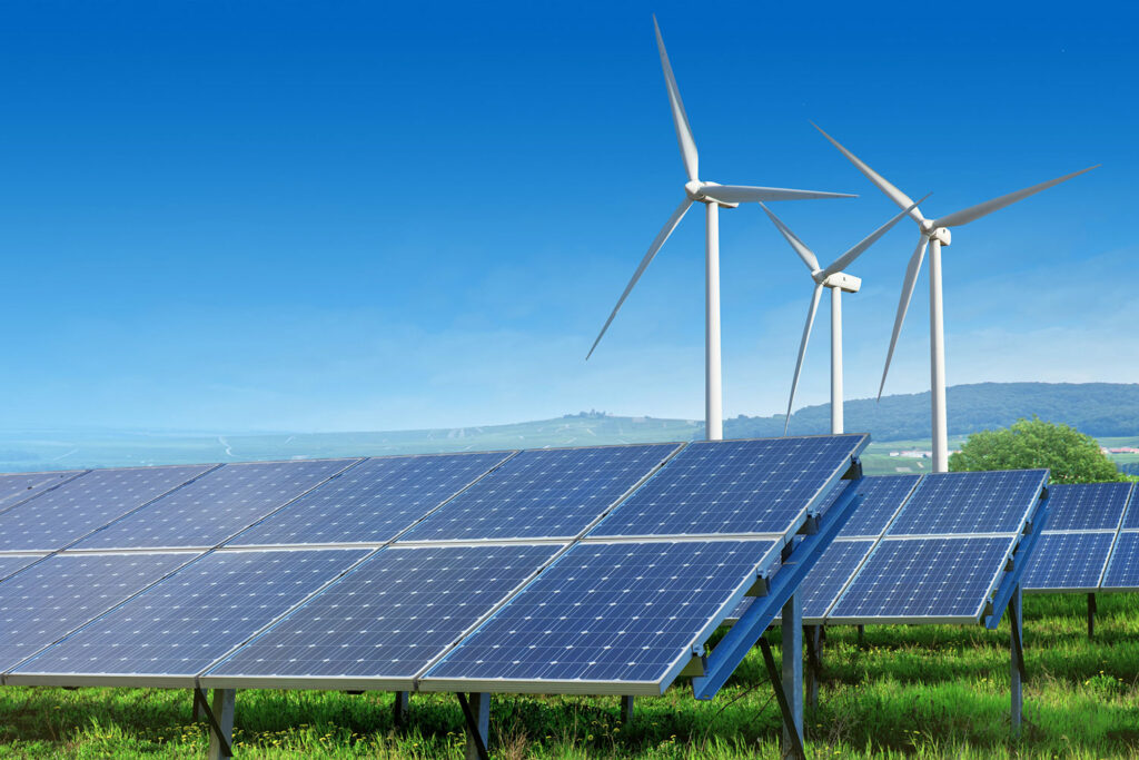Solar panels and wind turbines in field