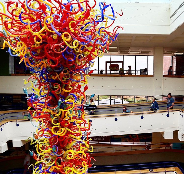 Colorful glass chandelier sculpture hanging in atrium