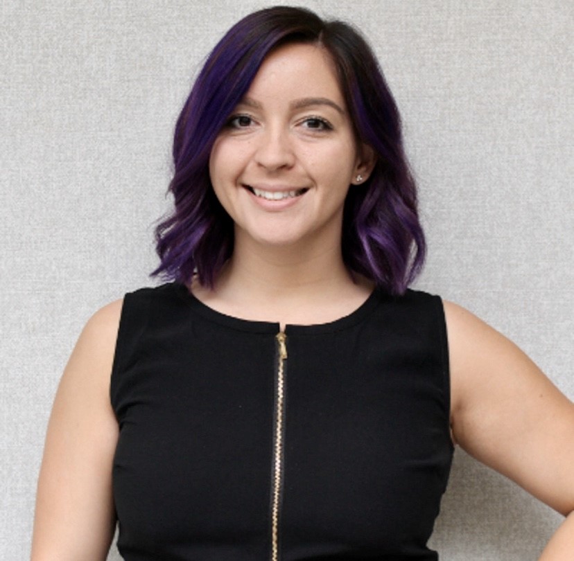 Smiling woman with purple hair and black top