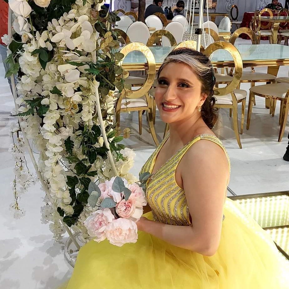 Woman in yellow gown holding pink bouquet