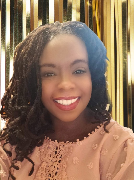 Smiling woman with dreadlocks against gold backdrop