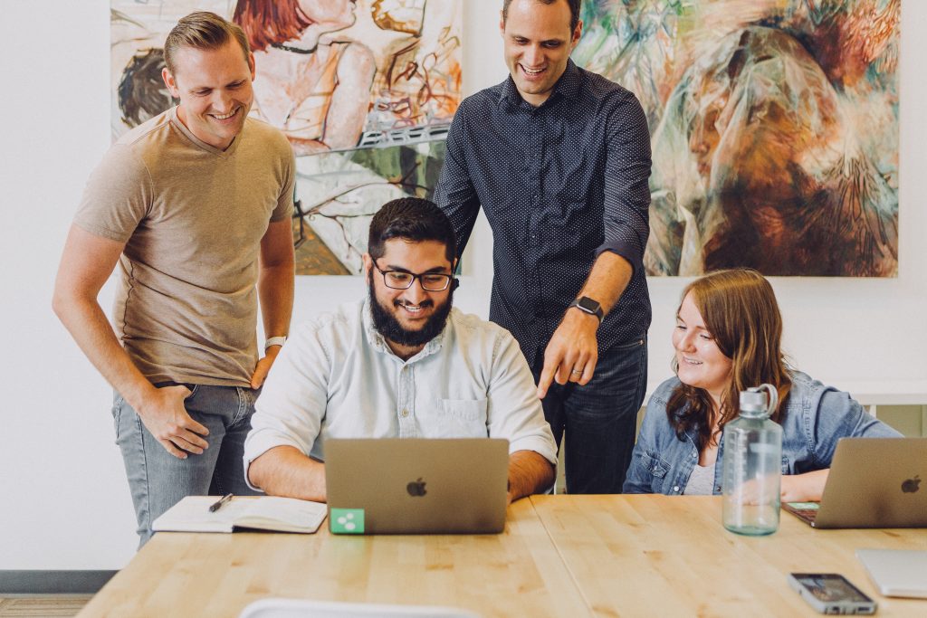 Team collaborating around laptop in office