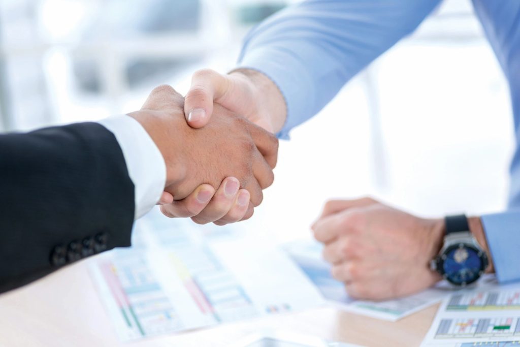 Business handshake over financial documents