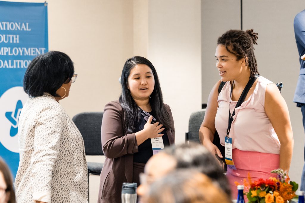 Three women conversing at professional conference