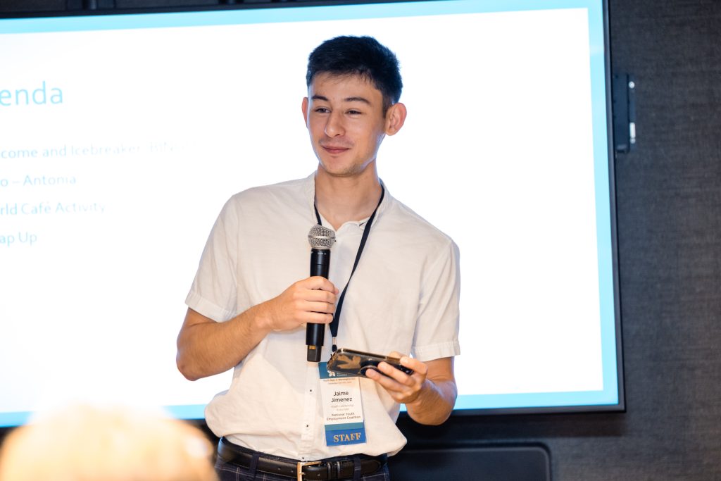 Young man speaking into microphone at presentation