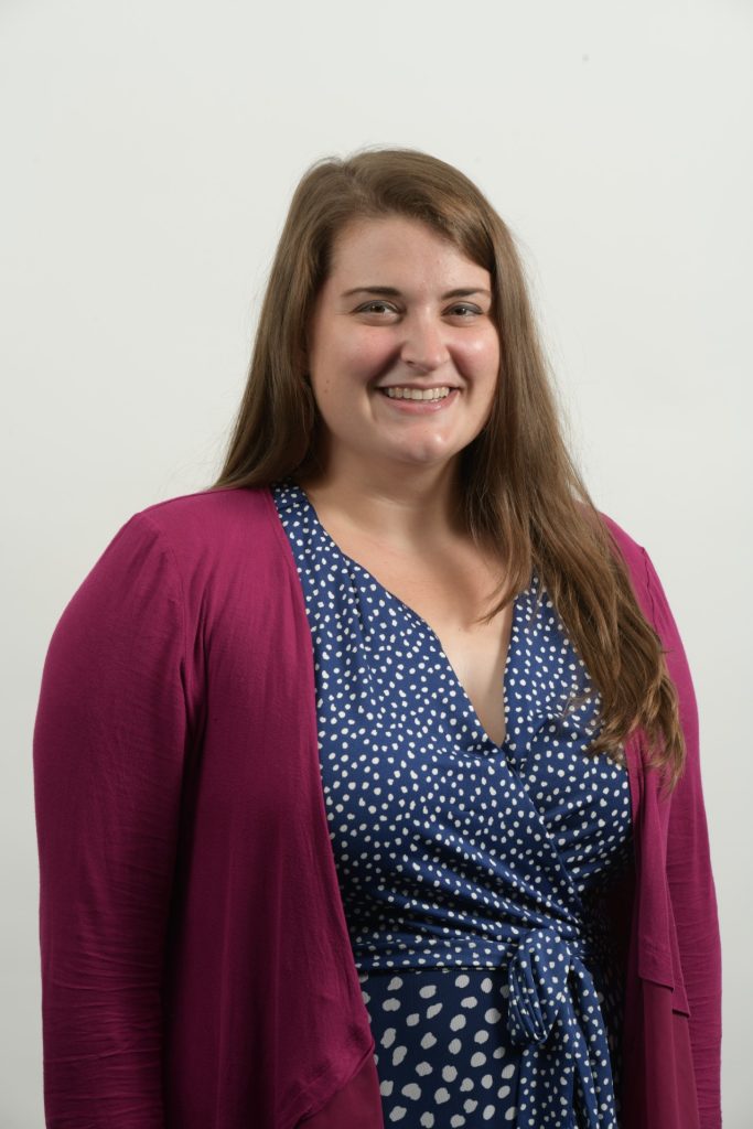 Smiling woman in polka-dot dress and cardigan