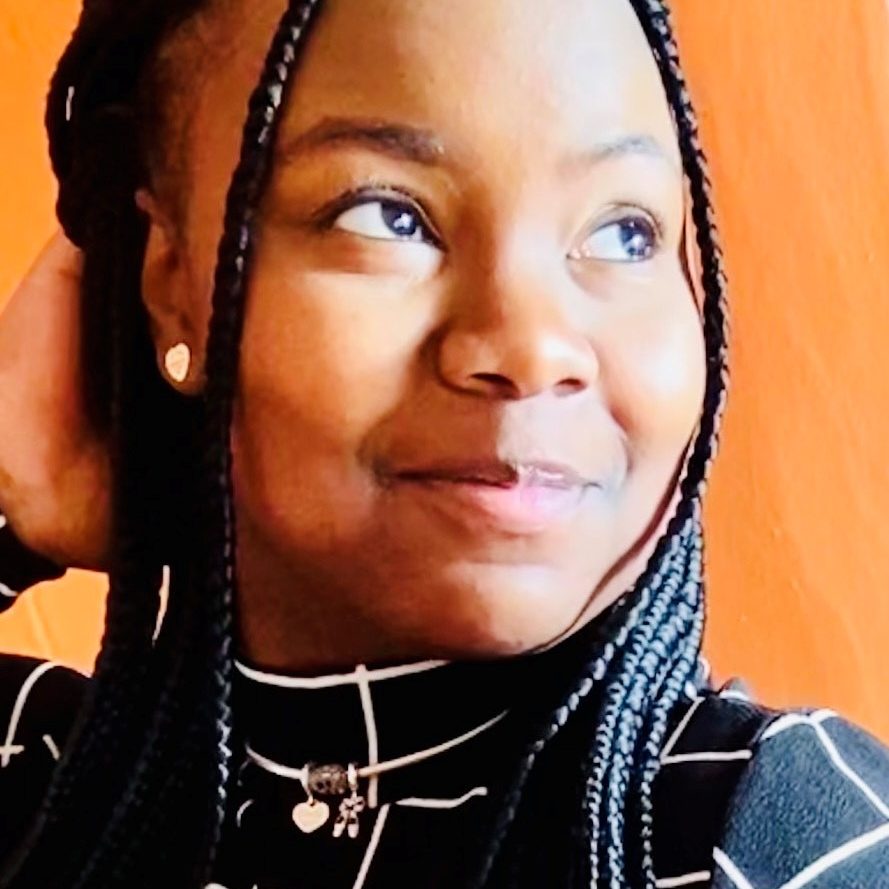 Smiling person with braids looking sideways